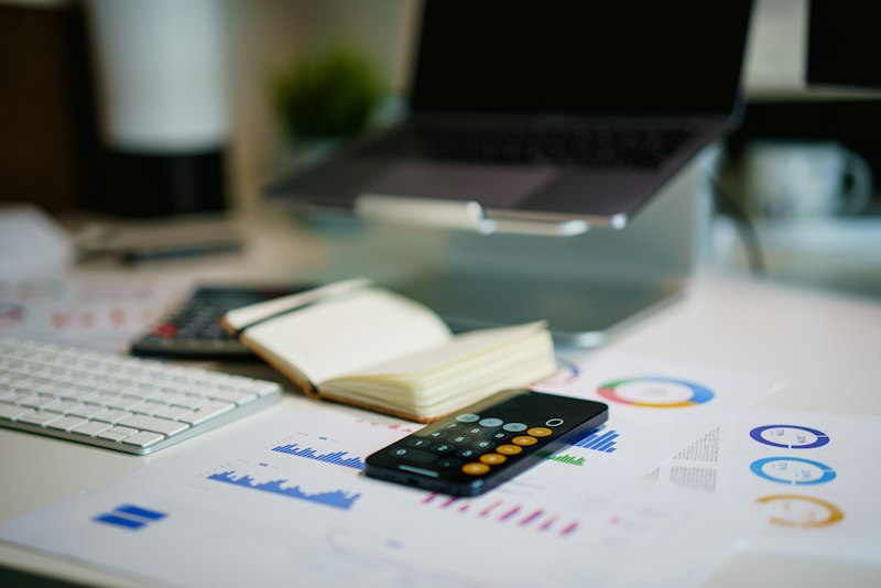 Office desk with smartphone and financial charts