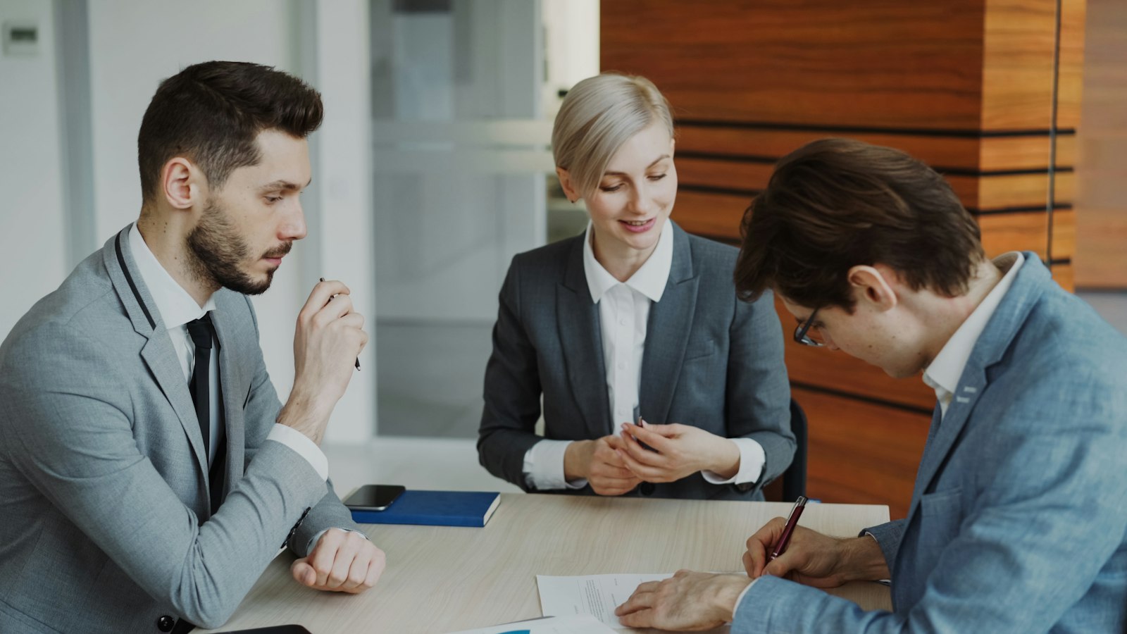 People signing a contract at a table