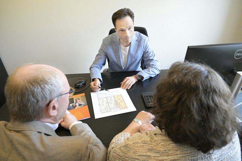 Consultant explains plans to a couple during a meeting